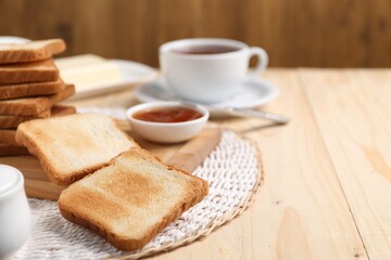 Slices of tasty toasted bread and jam on wooden table, closeup. Space for text
