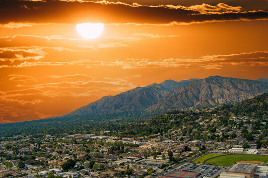 aerial shot of Monrovia High school with majestic mountain ranges, homes and lush green trees in Monrovia California USA
