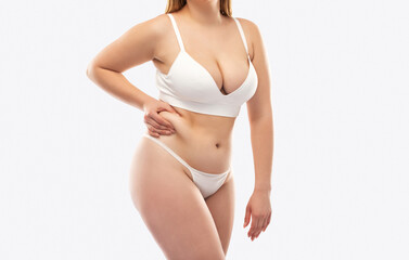 The girl stretches the skin on the leg and on the stomach, showing fat deposits. Treatment and...