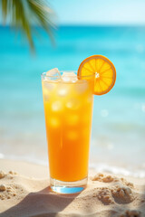 Refreshing orange juice with ice, garnished with a slice of orange, on tropical beach sand under palm shade by the turquoise sea