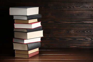Stack of old books on wooden table, space for text