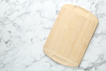 Fototapeta premium One wooden cutting board on white marble table, top view. Space for text