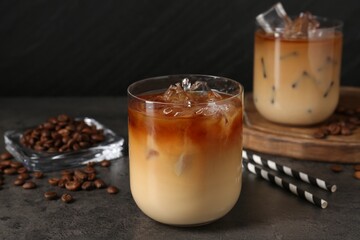 Tasty iced coffee and beans on grey table