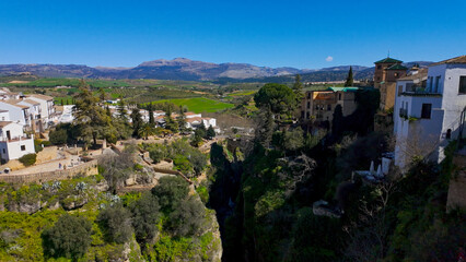 Obraz premium Ronda, Spain showcasing Puente Nuevo bridge, gorge, and white houses under blue sky