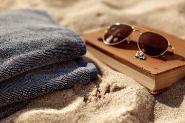 Beach Still Life with Sunglasses, Book and Towel in the Sand. Generative AI.