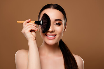 Portrait of adorable lovely lady makeup artist hold brush apply powder isolated on beige color...