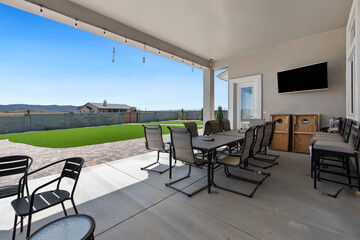 A patio with a table, chairs, and a flat screen TV for entertainment