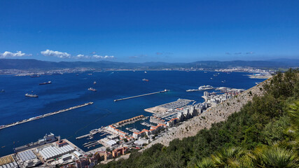 Gibraltar harbor and Algeciras Bay embracing cargo ships under blue sky