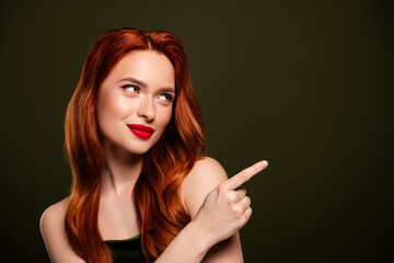 Obraz premium Attractive femme fatale lady point looking pointing finger empty space promo banner isolated on khaki color background