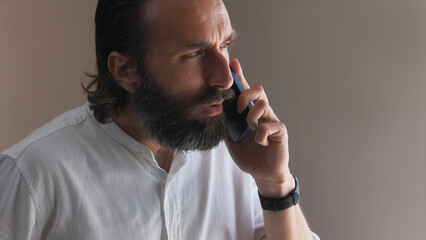 Bearded Man Engaged in Professional Conversation on Smartphone