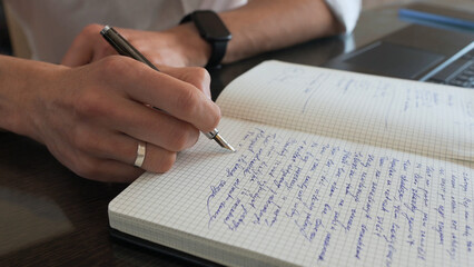Professional Writer Taking Notes in a Journal at Workplace Desk
