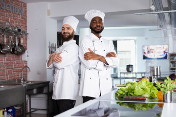 Diverse chefs in uniform preparing a delicious meal in a professional kitchen, preparing fresh...