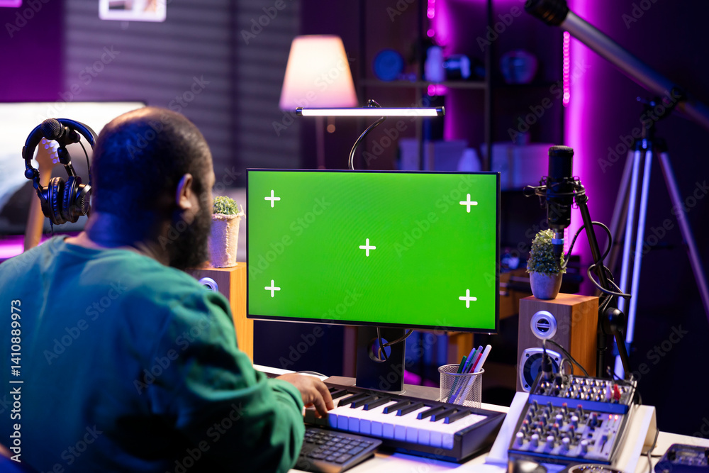 Aufkleber musician operates on midi controller piano keys next to mockup screen, producing new songs with musi