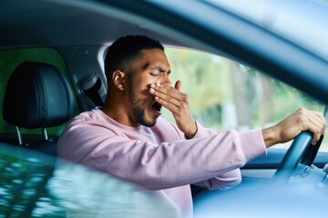 Driver yawns and struggles to stay awake behind the wheel, indicating fatigue or drowsy driving risk.