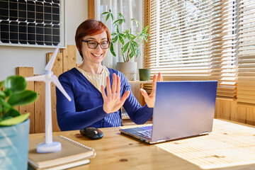 Businesswoman working from home in renewable energy sector reacts elatedly to news received in...