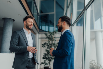 Two businessmen having a friendly conversation in modern office