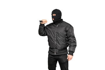 Masked thief holding flashlight is searching for valuables in the dark