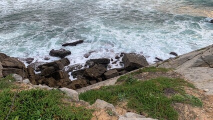 Rocky coastal shoreline with waves crashing, nature's serenity and adventure, ideal for travel...