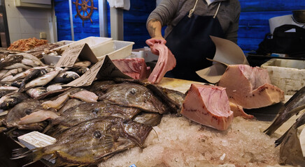 Fishmonger preparing fresh tuna and other fish at Cadiz market in Spain