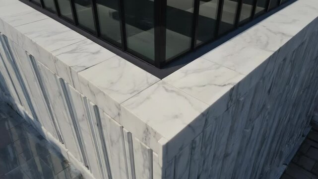 Corner detail shows marble architectural facade and modern glass structure with black frame, design elements, texture.