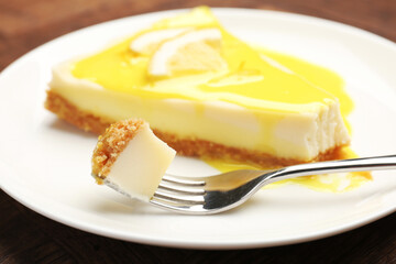 Piece of delicious cheesecake with lemon curd on table, closeup