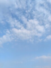 Naklejka premium Cloudy Blue Sky. A blue sky filled with fluffy clouds, natural lighting, high - quality