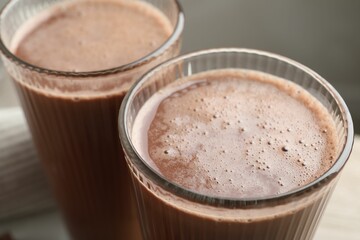 Tasty chocolate milk in glasses on table, closeup