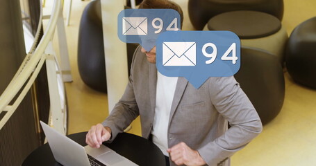 Image of emoji icons and numbers over man using laptop