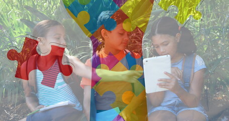 Image of colourful puzzle pieces hand over school children using tablets