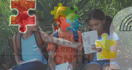 Image of colourful puzzle pieces over school children using tablets