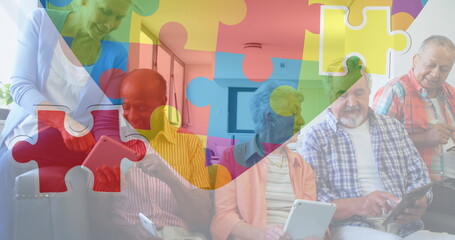 Image of colourful puzzle pieces heart over senior friends using tablets