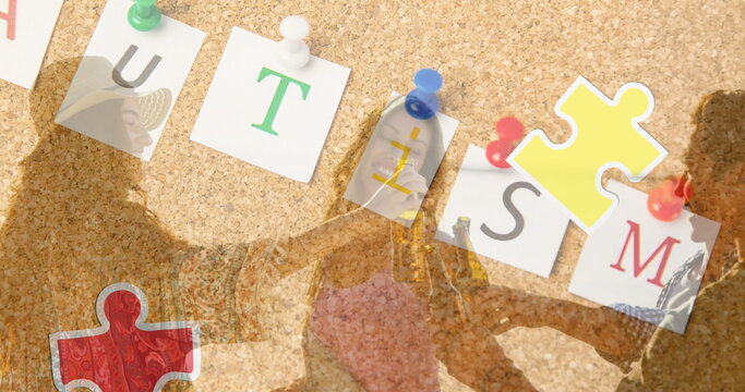 Image of colourful puzzle pieces heart and autism text over happy friends at summer beach party