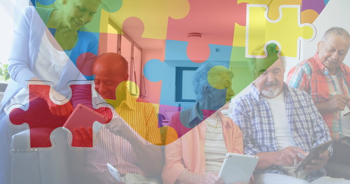 Image of colourful puzzle pieces heart over senior friends using tablets - Powered by Adobe