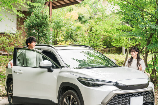 旅行でペンション・コテージに車でやってきたカップル・夫婦
