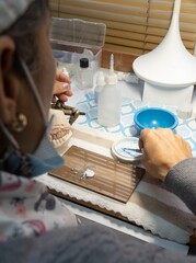 Close-up of a dental technician’s hands made a dental model with precision, showcasing artistry and professional expertise