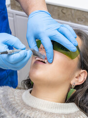 Treatment for tooth sensitivity. Dentist Performing Laser Procedure Inside Patient's Mouth