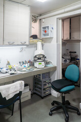 Dental laboratory workbench equipped with furnace, tools, and materials for manufacturing crowns, bridges, and other dental prosthetics. Dental technology workspace.
