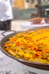 Chef preparing delicious paella with chicken, green beans, and saffron