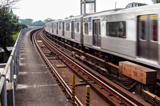 Sao Paulo, SP, Brazil - July 14 th, 2024: Curved subway train leaving Arm&ecirc;nia station towards Tiet&ecirc; station, highlighting the power cables feeding the third rail.