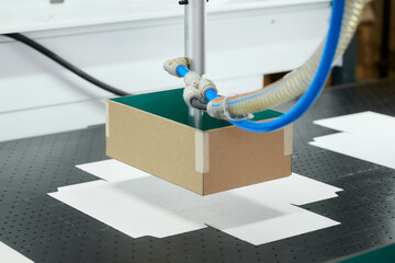Innovative robot technology streamlines cardboard box gluing process in manufacturing plant setting
