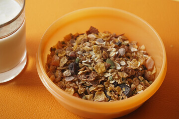 Healthy breakfast bowl with granola and milk served in kitchen