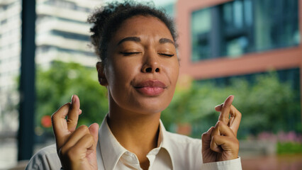 African American woman female girl businesswoman portrait crossed fingers hope dream wish gesture...