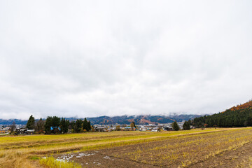 Fototapeta premium 新潟の山麓の紅葉と田園風景。雪国特有の雰囲気がある。 晩秋なので各所で紅葉が見られる。 新潟県魚沼市 - 2024年11月30日 