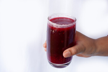 Woman holding glass of fresh beetroot smoothie isolated on white background, closeup. weight loss and healthy lifestyle drink. selective focus on subject.