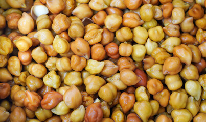 A small heap of brown chana on a pure white background. Dark brown, round, and slightly rough, with an earthy aroma and a nutty, hearty flavor.
