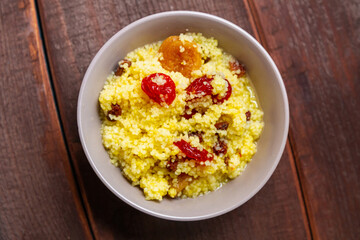 Couscous with dogwood nuts and raisins in a plate on the table.