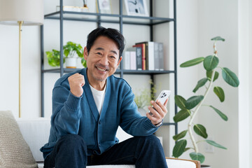 リビングでスマホを使うミドルの男性