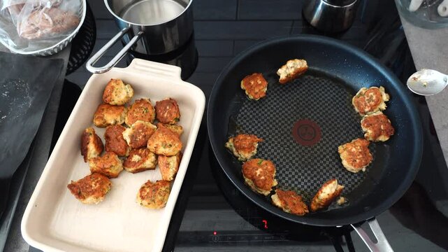 Stockholm, Sweden A cook fries Danish fish cakes, or Fiskefrikadeller, in oil over an induction stove.