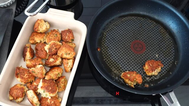 Stockholm, Sweden A cook fries Danish fish cakes, or Fiskefrikadeller, in oil over an induction stove.