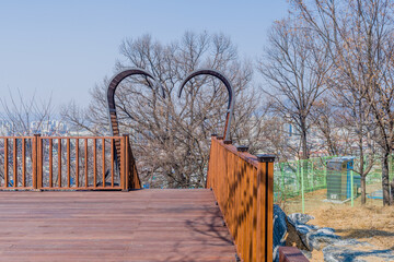 Wooden deck with heart-shaped metal feature over stairway exit.